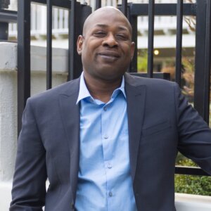 Corey Evans smiling headshot wearing a suit