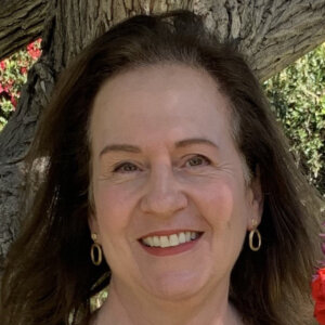 Sharon Swerdlow smiling headshot in front of a tree