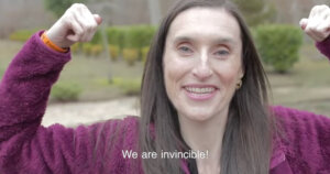 Still from Invincible short film with Kelly Considine flexing. Caption: "We are invincible!"