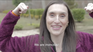 Still from Invincible short film with Kelly Considine flexing. Caption: "We are invincible!"