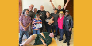 Group photo of the cast and crew behind Taco Tuesday, with John Lawson lying on the floor