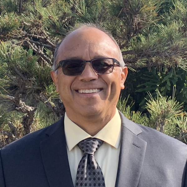 Jaime Pacheco Orozco smiling headshot wearing glasses and a suit and tie