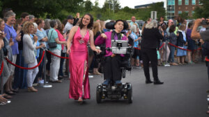 Samuel Habib and a young woman moving through a crowd of people cheering them on in a scene from My Disability Roadmap