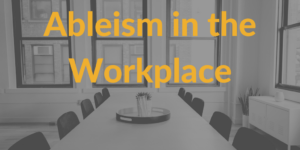 A conference room table in an office with empty chairs around it. Text: Ableism in the workplace.