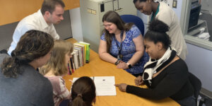 RespectAbility apprentices look at a document on a table together