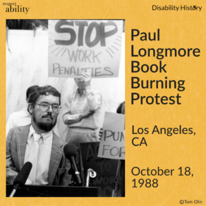 Black and white photo of Paul Longmore sitting in a wheelchair, wearing glasses and in front of a microphone. Behind him are fellow protesters and one holds a sign that says, “Stop work penalties.” Text: Paul Longmore Book Burning Protest. Los Angeles, CA. October 18, 1988. Source: Tom Olin.