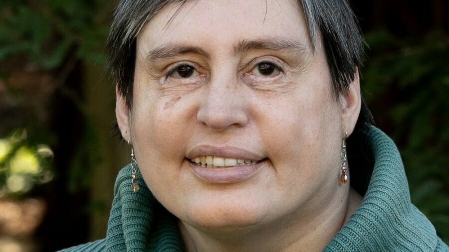 Carey McIntosh smiling headshot wearing a green sweater