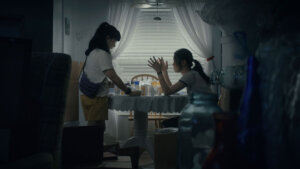 Jeena Yi and Anna Sargent in Take Me Home at a dinner table having an argument