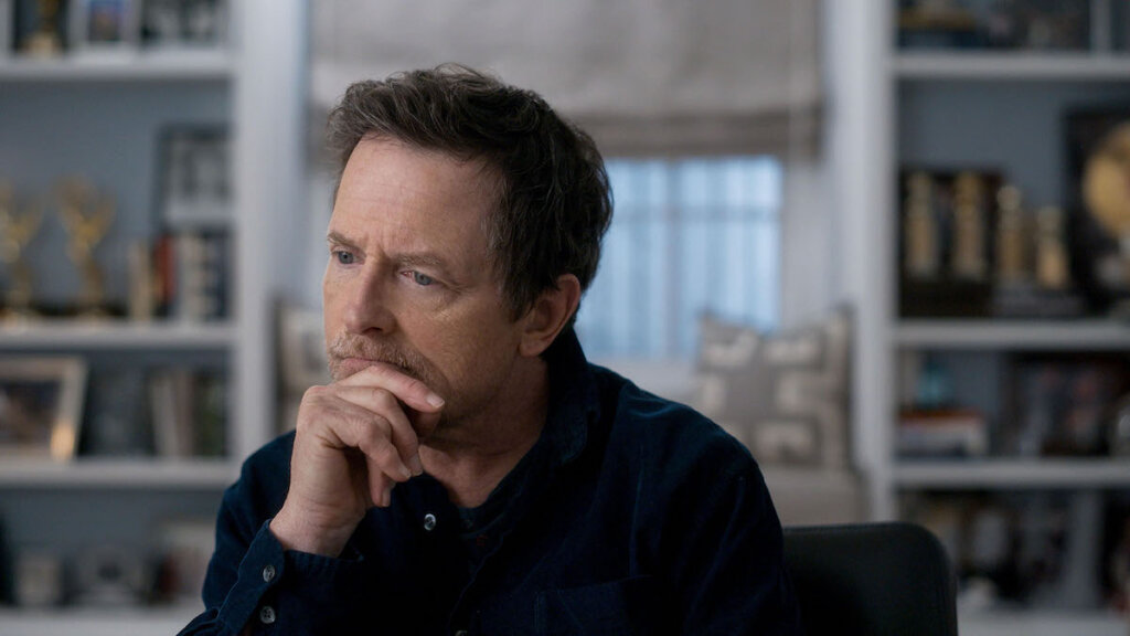 Michael J. Fox with his hand on his chin in a scene from "Still"