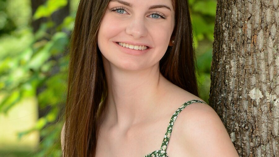 Audrey Bayne smiling headshot standing in front of a tree