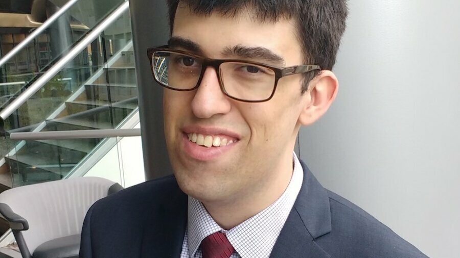 John Arsenault smiling headshot wearing a suit and tie