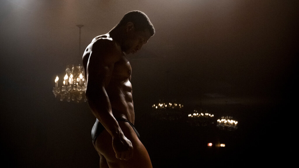 Still of Jonathan Majors in "Magazine Dreams" wearing only underwear in a darkly lit room