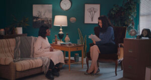 Kitoko Mai and Morgan Bargent sitting in an office having a conversation in a scene from Thriving