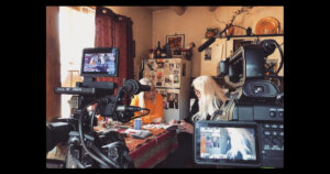 Faith Strongheart looking through a notebook with another woman in a behind-the-scenes still from her documentary