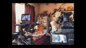 Faith Strongheart looking through a notebook with another woman in a behind-the-scenes still from her documentary