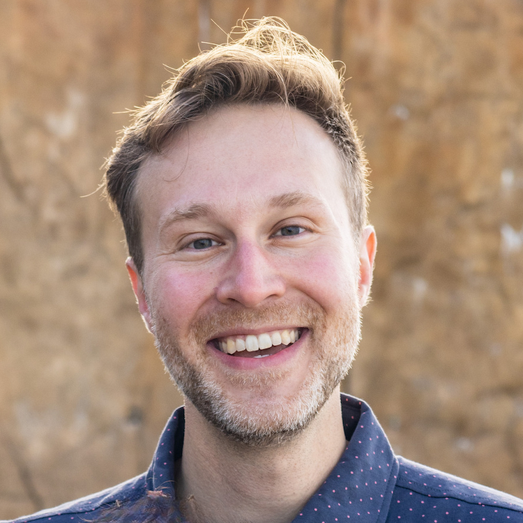 Christopher James smiling headshot wearing a blue dress shirt