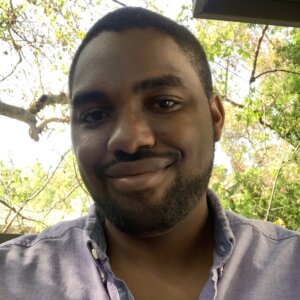 Matthew Charles smiling headshot outside in front of trees
