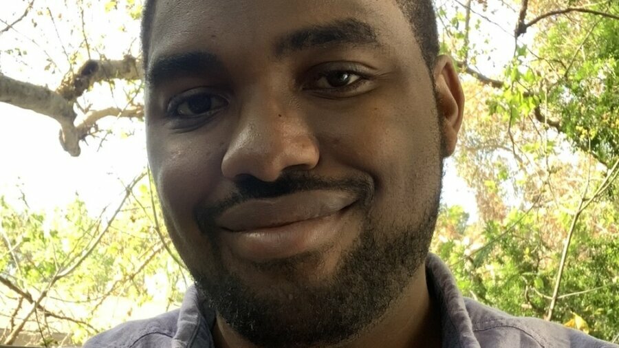 Matthew Charles smiling headshot outside in front of trees