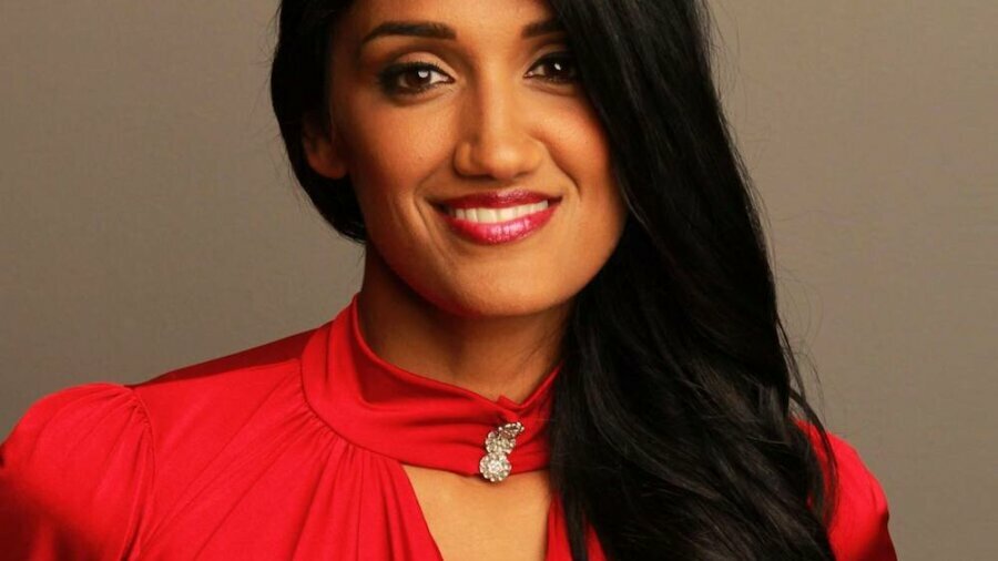 Radha Mehta smiling wearing a red dress