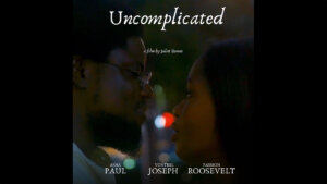 poster for "Uncomplicated" by Juliet Romeo featuring the two lead actors looking at each other in a dark environment