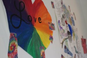 rainbow artwork of a heart with the word "love" written in cursive on it.