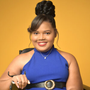 Candis Welch smiling headshot seated in her wheelchair