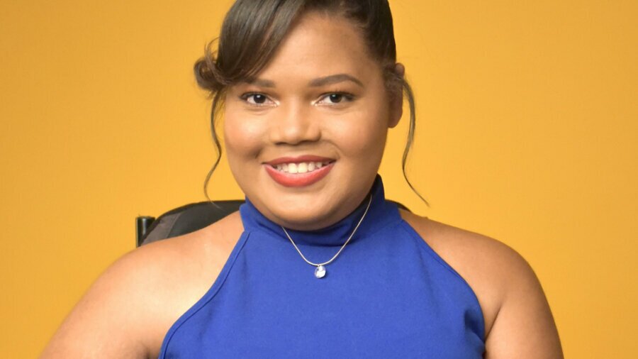 Candis Welch smiling headshot seated in her wheelchair