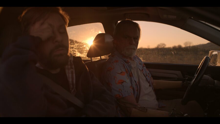 still from Daruma with Tobias Forrest and John Lawson driving in a car at sunset