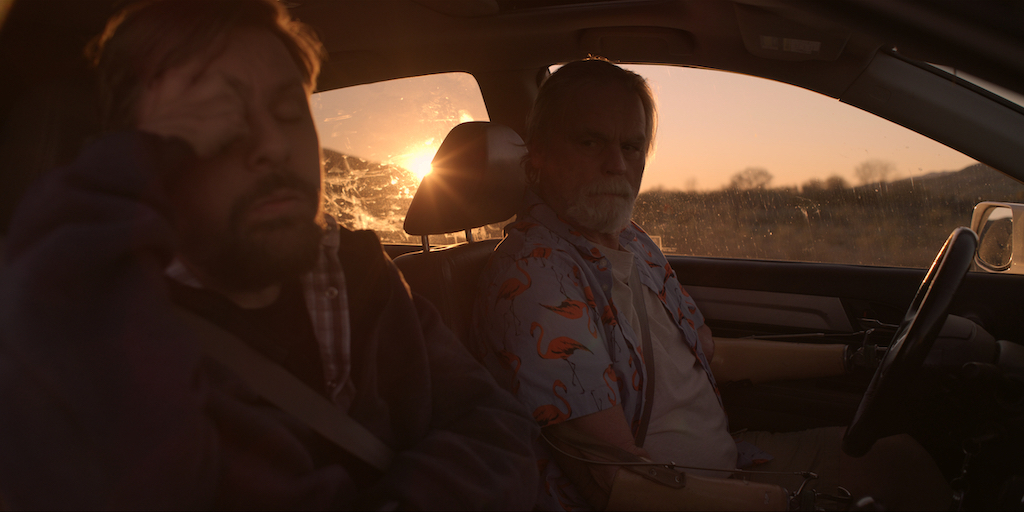 still from Daruma with Tobias Forrest and John Lawson driving in a car at sunset