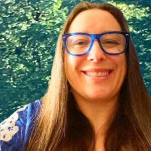 Grace Ogden Parker smiling headshot wearing blue glasses