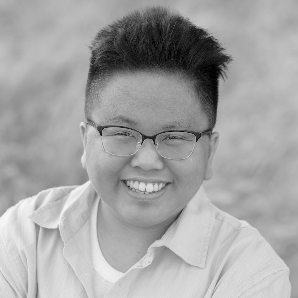 Nancy Yang smiling headshot wearing a light colored button down shirt and glasses
