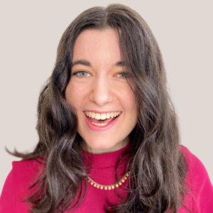 Noa Porten smiling headshot wearing a pink shirt and gold necklace