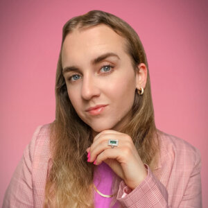 Julian Gavino smiling headshot wearing a pink patterned blazer