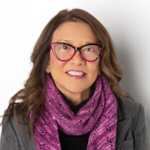 Toby G. Wong headshot smiling wearing glasses and a purple scarf around her neck