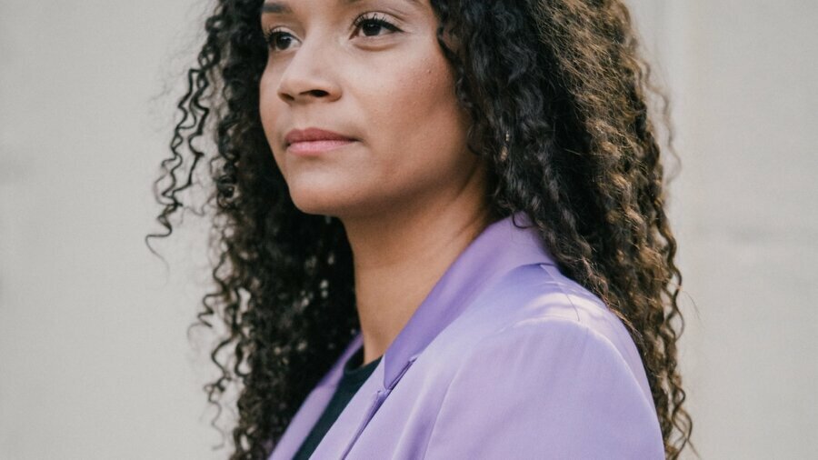 Aisha Becker-Burrowes smiling headshot wearing a purple blazer