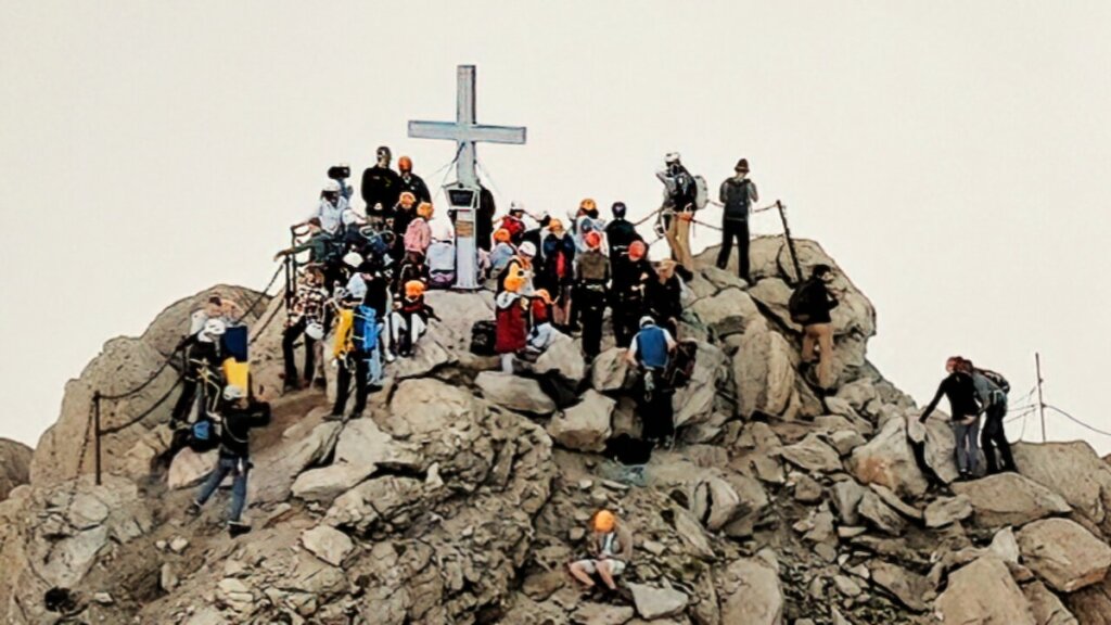 still from Camp Courage with Ukrainian refugees together on a mountain with a cross on it