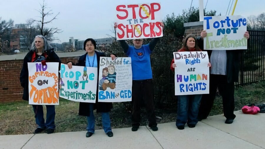 Protesters holding signs that say things like 