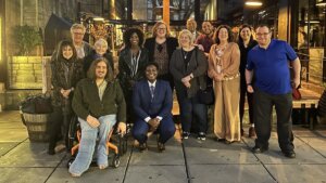 RespectAbility staff and board members smile together outside a restaurant in Washington DC