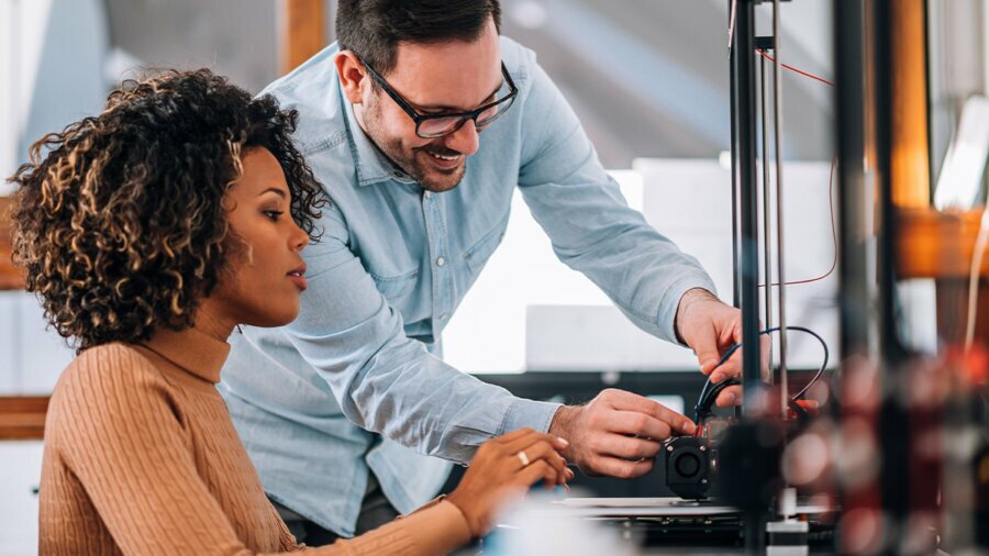 Two people working together to wire something