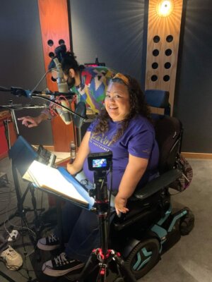 Jennifer Kumiyama, a disabled actress, smiling while recording her lines for WISH