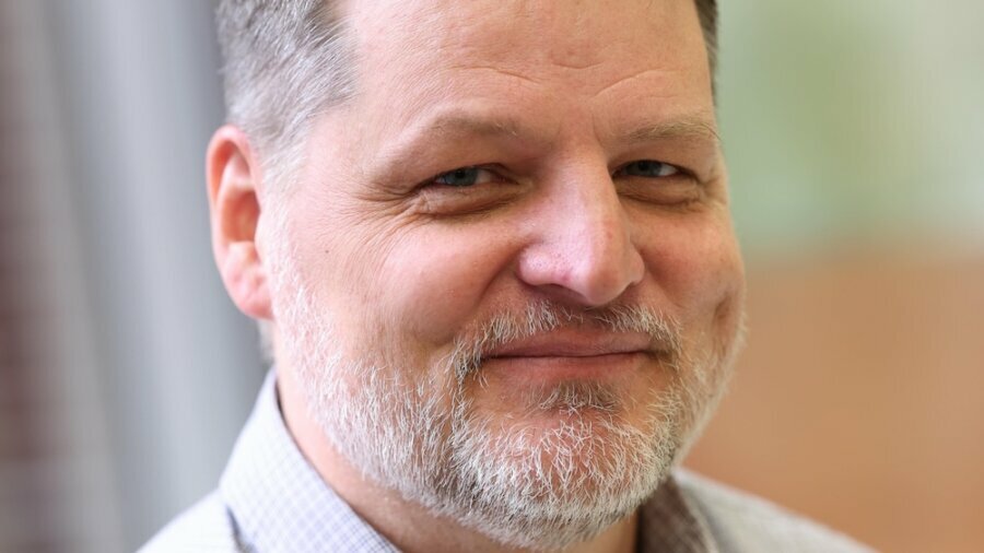 Erik Carter smiling headshot wearing a dress shirt