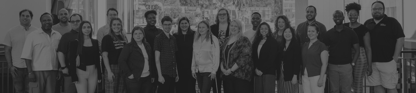 black and white photo of RespectAbility Staff smiling together with the Hollywood sign in the distant background