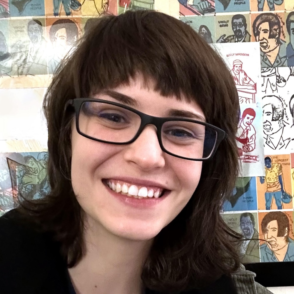 Chloe Moon smiling headshot in front of a wall of artwork