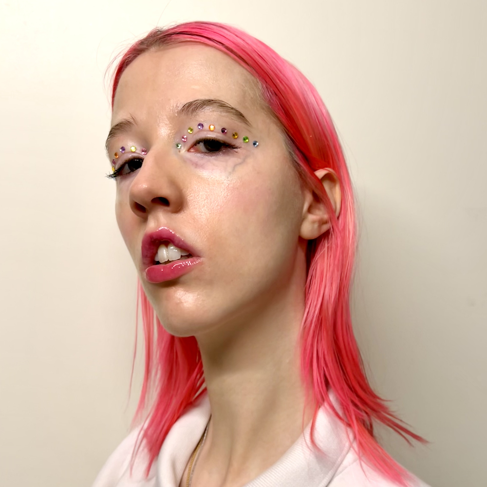 Emma Layden smiling headshot with glitter around her eyes