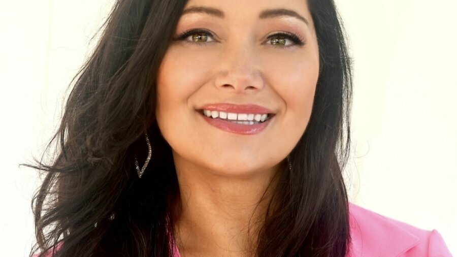 Genevieve McDevitt smiling headshot wearing a pink blazer