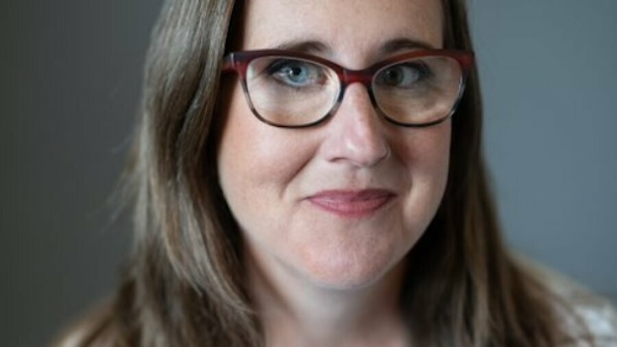 Katherine Craft headshot wearing a white shirt and glasses