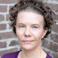 Maggie Whittum headshot wearing a purple shirt