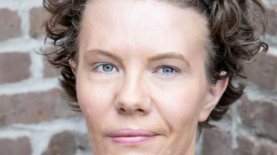 Maggie Whittum headshot wearing a purple shirt