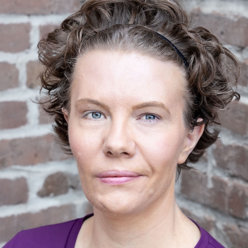 Maggie Whittum headshot wearing a purple shirt