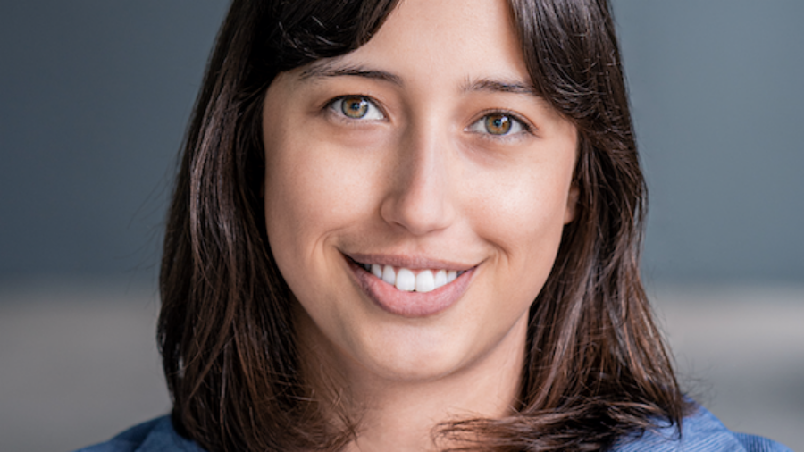 Monica Cecilia Lucas smiling headshot wearing a denim colored jacket